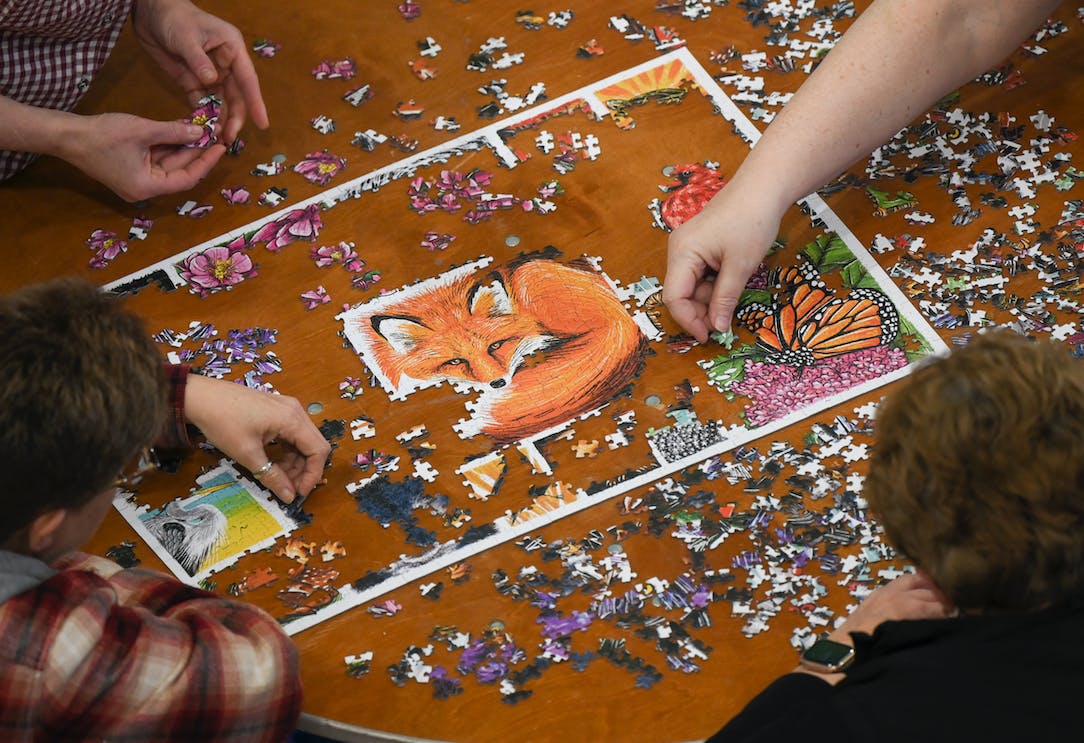 Hands working on jigsaw puzzle