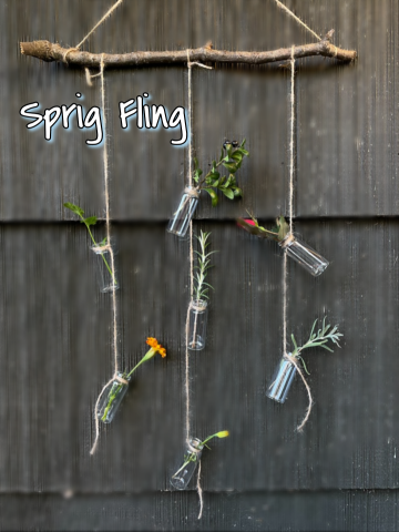 A picture of the completed Sprig Fling craft. Little bottles with sprigs in them, tied with string, hanging from a stick.