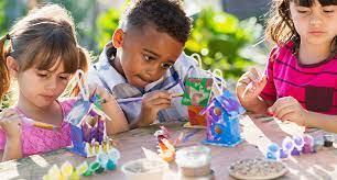 Three small children working on craft projects.