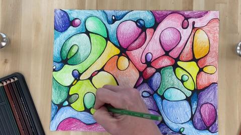 A hand drawing a multi-color drawing