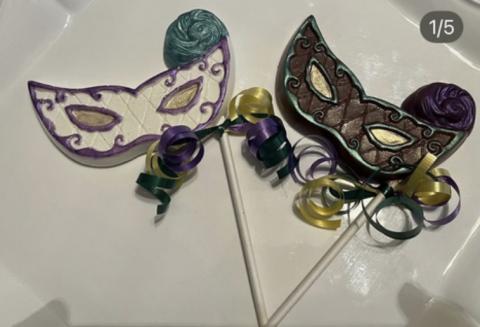 A picture of two lollipops that look like Mardi Gras masks