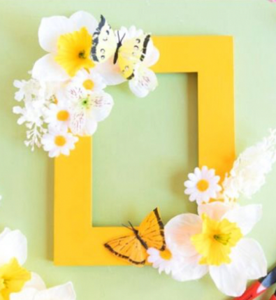 Picture of a yellow frame with flowers and butterflies on two corners of the frame.