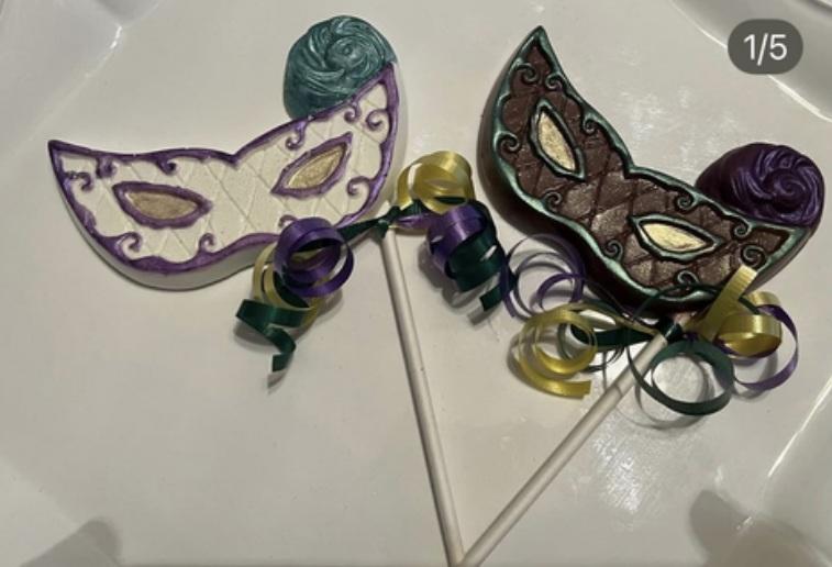 A picture of two lollipops that look like Mardi Gras masks